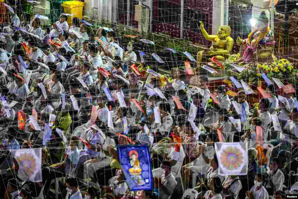 As pessoas rezam para celebrar o ano novo de 2025 num templo em Banguecoque, Tailândia, a 31 de dezembro de 2024.