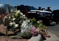 Flowers adorn a makeshift memorial near the scene of a mass shooting at a shopping complex in El Paso, Texas, Aug. 4, 2019.
