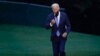 FILE - President Joe Biden takes off his mask as he walks from Marine One on the South Lawn of the White House in Washington, Oct. 5, 2021, after returning from a trip to Michigan to promote his infrastructure plan.