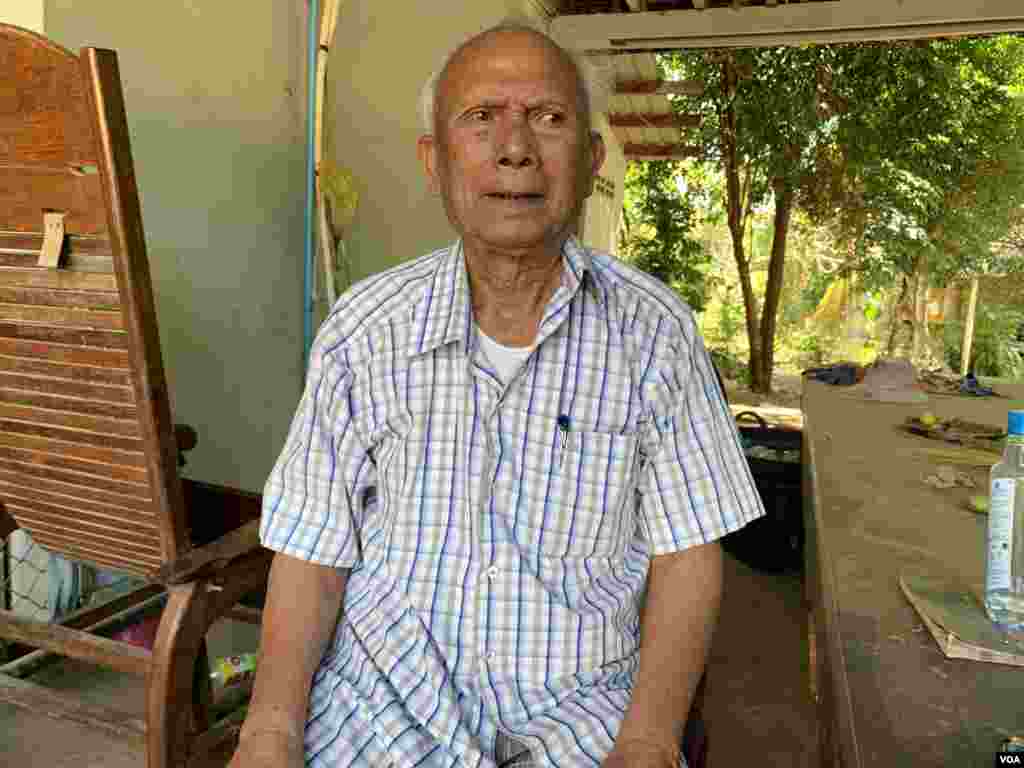 លោក មាស មុត អតីតមេបញ្ជាការកងទ័ពជើងទឹករបស់របបខ្មែរក្រហម ដែលរឿងក្តីរបស់លោកកំពុងបន្តទៅមុខទាំងភាពមិនច្បាស់លាស់នៅសាលាក្តីខ្មែរក្រហម អង្គុយនៅក្នុងគេហដ្ឋានរបស់លោកនៅស្រុកសំឡូត ខេត្តបាត់ដំបង ថ្ងៃទី១៦ ខែធ្នូ ឆ្នាំ២០១៩។ (សុខ ខេមរា/VOA)