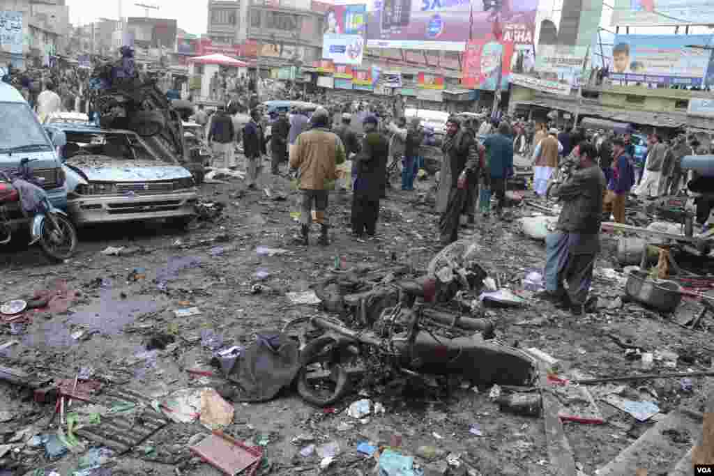People walk around the debris from a bomb blast in Quetta, Pakistan, January 10, 2013. (Hameed Samsor/VOA)