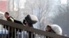 Migrant workers carrying their belongings walk up an overpass near the railway station upon arriving in Beijing, 02 March 2010