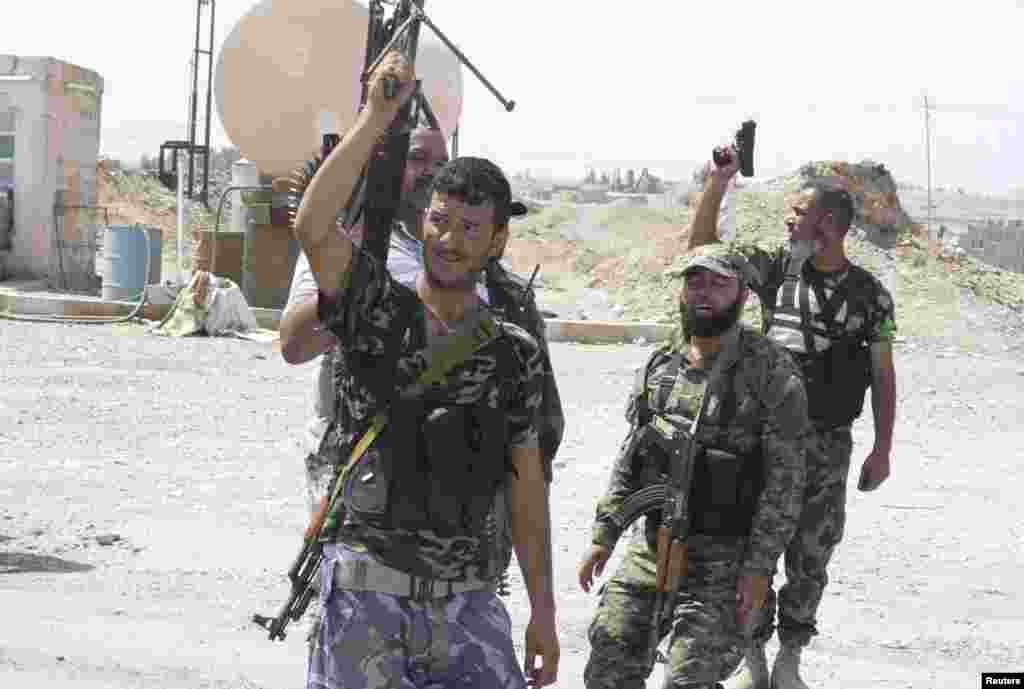 Shi'ite volunteers carry their weapons during an intensive security deployment to fight against militants of the Islamic State, formerly known as the Islamic State of Iraq and the Levant (ISIL), in the town of Tuz Khurmatu, Iraq, Aug. 31, 2014.