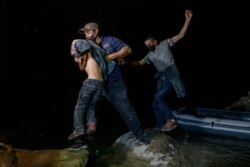 Migrantes de Centroamérica que cruzan ilegalmente de México a Estados Unidos para buscar asilo desembarcan de un bote inflable en el lado estadounidense del río Grande en la ciudad fronteriza de Roma el 29 de marzo de 2021.