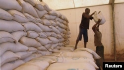 FILE - Men transport humanitarian food aid onto trucks in Sevare, Mali, Feb. 4, 2013. 