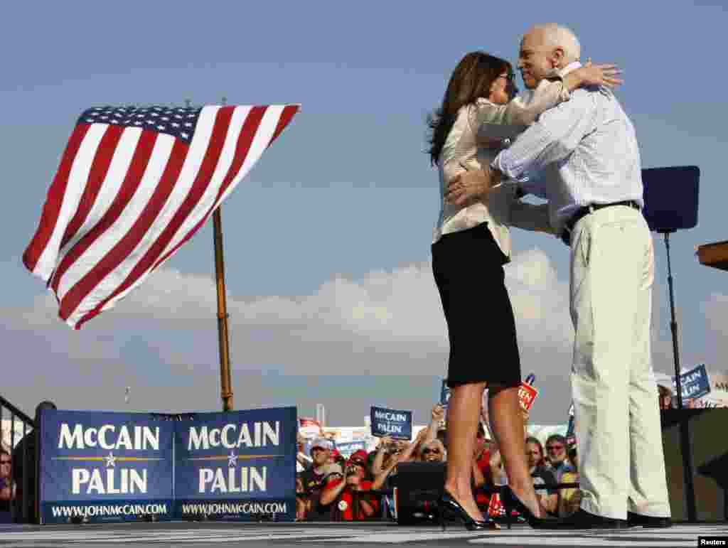 US Republican presidential candidate Senator John McCain (R-AZ) and his running mate Alaska Governor Sarah Palin hug during a campaign stop in O'Fallon, Missouri, Aug. 31, 2008.