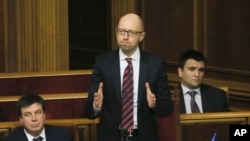 Ukrainian Prime Minister Arseniy Yatsenyuk, center, reacts after surviving a vote of no confidence, in Parliament in Kyiv, Ukraine, Tuesday, Feb. 16, 2016.