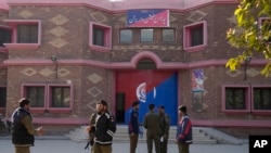 Polisi berkumpul di luar kantor polisi di distrik Nankana, Pakistan di mana tersangka penista Al-Qur'an diseret oleh ratusan massa dan digantung, Minggu (12/2). 