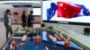 FILE - Visitors look at models of tanker-shaped floating nuclear reactors and oil rigs showcased at the China International Exhibition on Nuclear Power Industry in Beijing on April 27, 2017. China is developing floating nuclear reactors for the South China Sea.