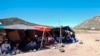 ARCHIVO: Un grupo de personas esperan a ser procesadas después de cruzar la frontera entre México y Estados Unidos para solicitar asilo, el miércoles 17 de abril de 2024, cerca de Jacumba, California. 