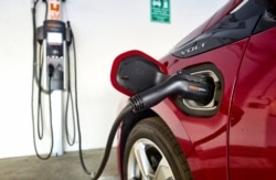 FILE - A Chevrolet Volt hybrid car is hooked up at a ChargePoint charging station at a parking garage in Los Angeles, Oct. 17, 2018.