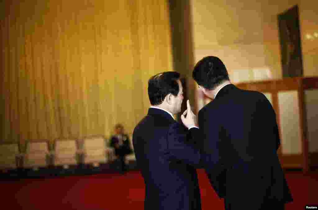 中共18大代表在参加一次会议前,在人民大会堂的广西厅前聊天。(2012年11月8日)