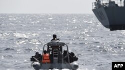 Les forces spéciales nigérianes naviguent pour intercepter des pirates lors d'un exercice conjoint entre le personnel naval nigérian et marocain dans le cadre d'Obangame Express, un exercice maritime multinational impliquant 33 pays au large de Lagos, le 20 mars 2019.