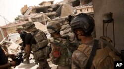 FILE - Iraqi special focus advance to their next position in the Islah al-Zarai area in Mosul, Iraq, May 11, 2017. 