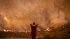 Une femme regarde des incendies de forêt ravager une forêt dans la région de Chefchaouen, dans le nord du Maroc, le 15 août 2021.
