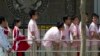 FILE - Chinese students wait outside the U.S. Embassy for their visa application interviews in Beijing, China.