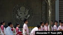 Chinese students wait outside the U.S. Embassy for their visa application interviews in Beijing, China.