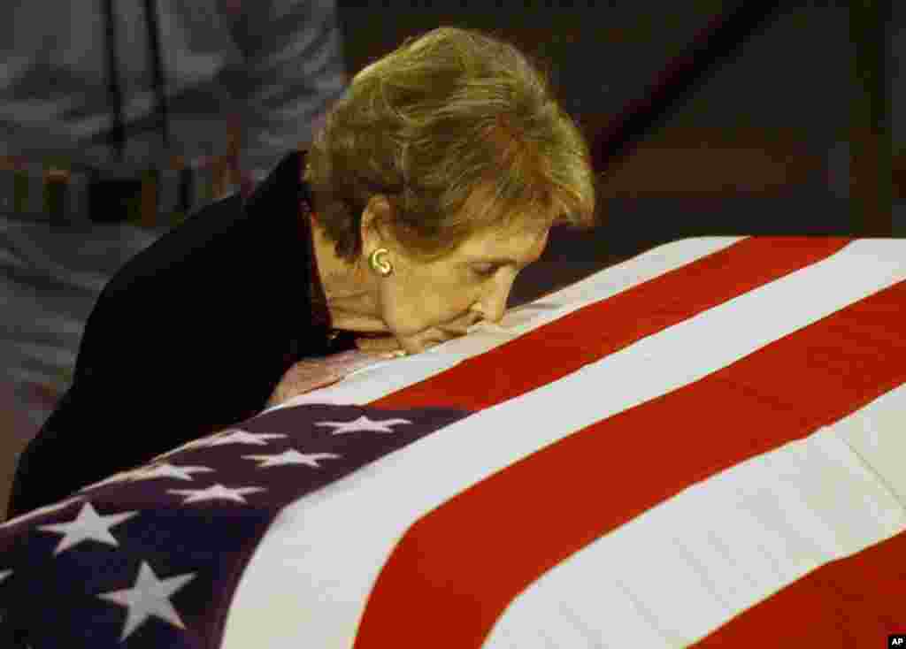 Mantan ibu negara AS Nancy Reagan mencium peti mati suaminya, mantan Presiden Ronald Reagan sebelum jenazah dipindahkan dari Capitol Rotunda di Washington, 11 Juni 2004. (AP/Elise Amendola, File)