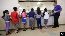 Anak-anak imigran mengantre makanan di kafetaria Pusat Penampungan Karnes County, di Karnes City, Texas, 10 September 2014.