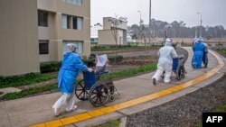 En esta foto de archivo tomada el 28 de agosto de 2020, pacientes que se recuperaron del COVID-19 son trasladados en sillas de ruedas por trabajadores de la salud luego de ser dados de alta.