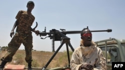 Somali government soldiers looking out from a machine gun mounted pick-up truck at Tobanka Buundo in the lower Shabelle region, near the Somalian capital Mogadishu, where residents created a road block during a protest against the Islamist Al-Shabab insur