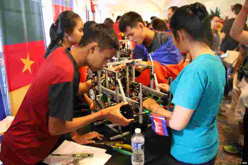 Cambodian youth robotics team examine their robot during the First Global Challenge robotics competition in Washington, DC, Monday, July 17, 2017. (Nem Sopheakpanha/VOA Khmer)