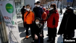 韩国新冠病毒确诊病例不断攀升，重灾区大邱市民众阅读有关邮局贩卖口罩的说明(2020年3月5日)
