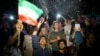 FILE - A group of jubilant Iranians cheer and spray artificial snow during street celebrations following the announcement of a landmark nuclear deal that meant the lifting of economic sanctions, in Tehran, July 14, 2015.