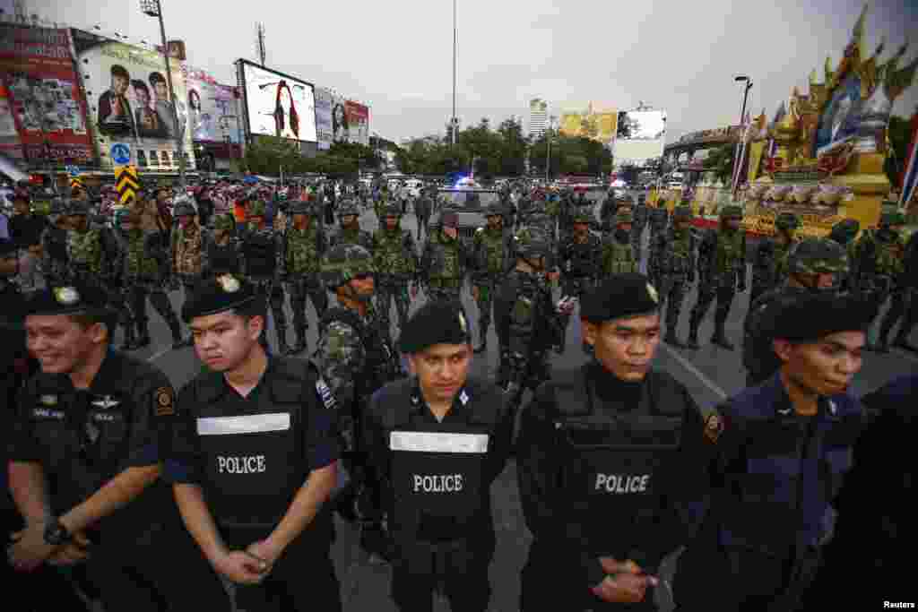 Police officers and soldiers stand guard during a protest against military rule at Victory Monument in central Bangkok, May 26, 2014.