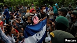 Migrantes hondureños que intentan llegar a EE.UU. son bloqueados por la guardia civil en una carretera para evitar que alcancen la frontera de México, en San Pedro Cadenas, Izabal, Guatemala, el 2 de octubre de 2020.