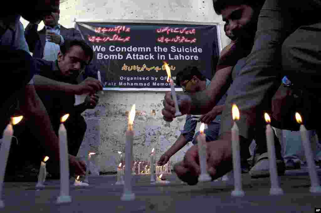Members of a civil society group light candles during a vigil for the victims of Sunday's suicide bombing, March 28, 2016 in Karachi, Pakistan.