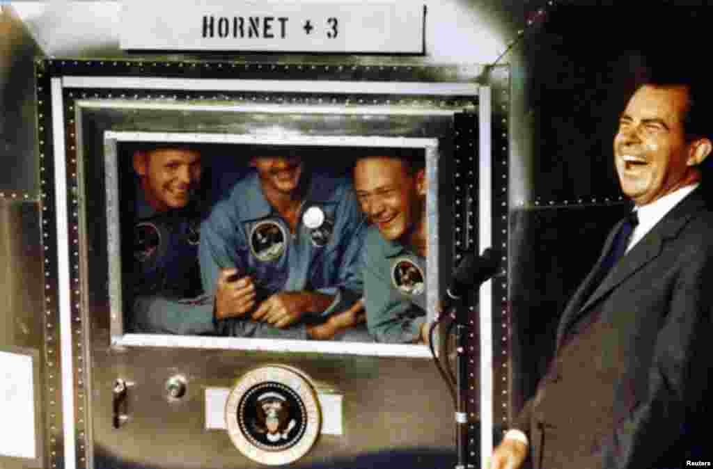 Para astronot Apollo 11 dari kiri: Neil Armstrong, Michael Collins, dan Edwin 'Buzz' Aldrin tertawa bersama Presiden AS Richard Nixon di atas kapal induk USS Hornet (foto: courtesy Richard Nixon Foundation, 24 Juli 1969).
