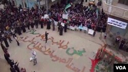Para demonstran oposisi berkumpul di kota Homs, Suriah di tempat yang bertuliskan: 'Kami Mencari Kebebasan dan Perdamaian' dan 'Kami bukan Pencuri atau Pelanggar Hukum.' (31/12)/
