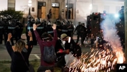Police attempt to push back protesters outside the Kenosha County Courthouse, Aug. 24, 2020, in Kenosha, Wisconsin. (AP Photo/David Goldman)