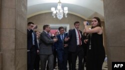 El presidente de la Cámara de Representantes de EEUU, el republicano Mike Johnson (en el centro), habla con varios periodistas al regresar a su oficina el 11 de enero de 2024, en Washington DC.