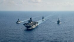 La fragata de misiles guiados de la Marina Real Australiana HMAS Parramatta (FFH 154) (L) navega con el buque de asalto anfibio de la Armada estadounidense USS America (LHA 6), el crucero de misiles guiados clase Ticonderoga USS Bunker Hill (CG 52) y la clase Arleigh-Burke guiada.