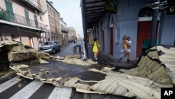 Bagian atap yang tertiup angin dari sebuah bangunan di French Quarter oleh Badai Ida menghalangi persimpangan, Senin, 30 Agustus 2021, di New Orleans. (Foto AP/Eric Gay)