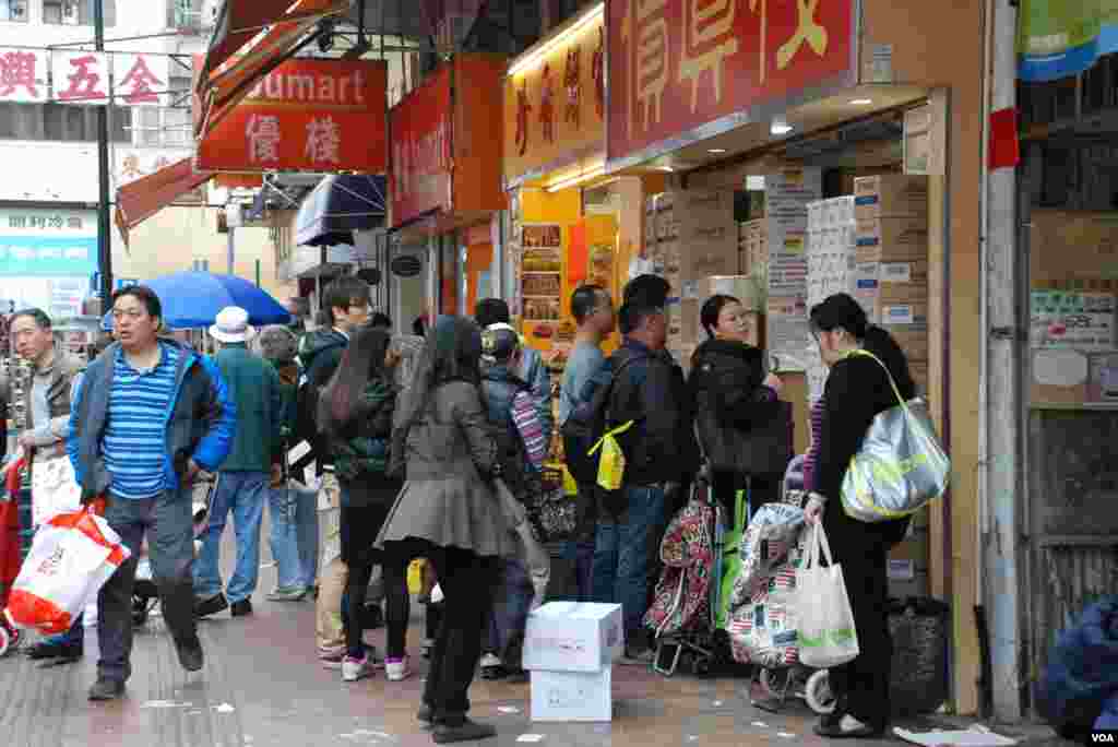 大批水貨客及大陸自由行旅客在上水石湖墟批發店排隊買年貨,有旅客表示要輪候20分鐘