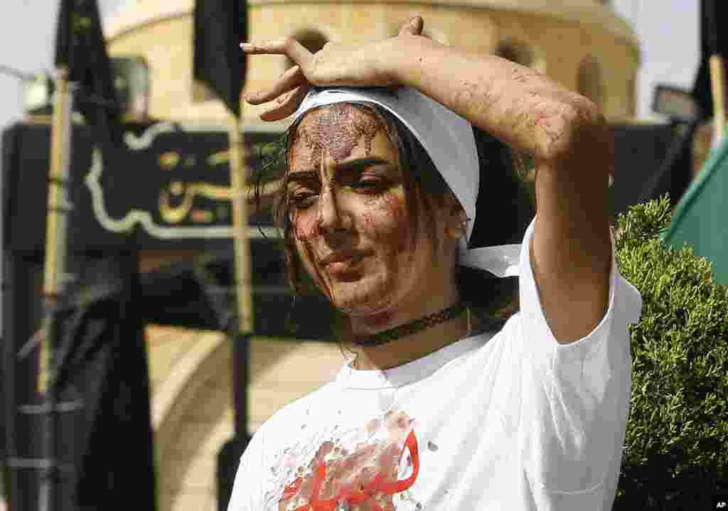A Lebanese Shi'ite woman bleeds from self-inflicted head wounds to show her grief during Ashura rituals in Nabatieh, Oct. 12, 2016.