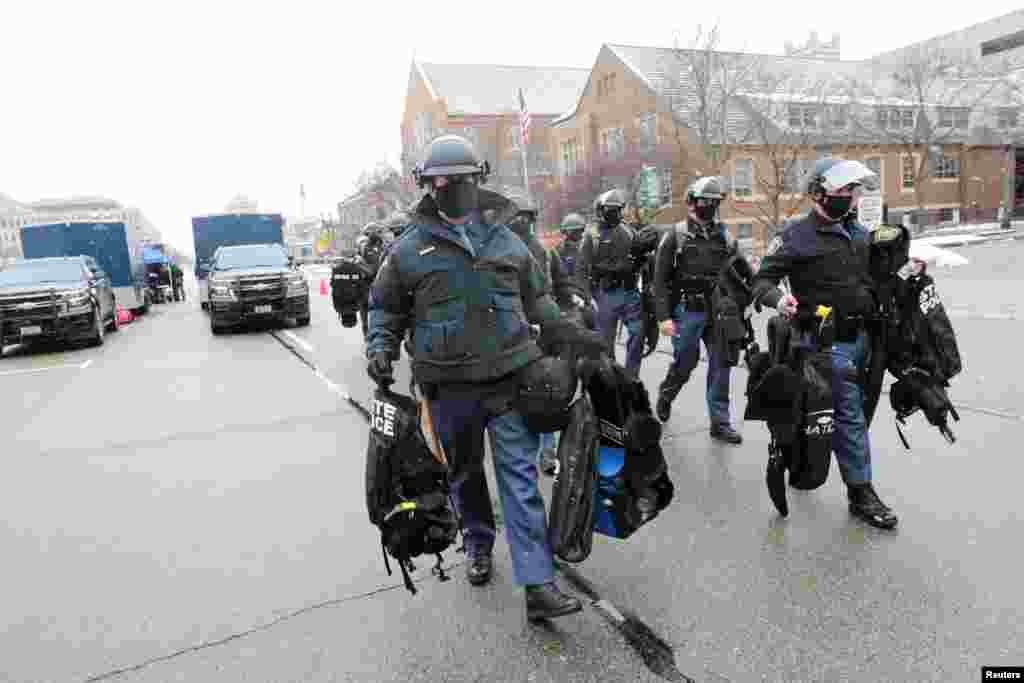 En la ciudad de Lansing, Michigan, miembros de la policía estatal arriban a la zona que cuidarán.17 de enero de 2021.