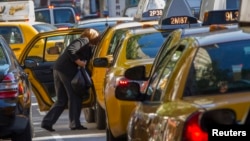 FILE - A woman exits a taxi on Third Avenue in heavy traffic caused in New York, Sept. 24, 2013. 