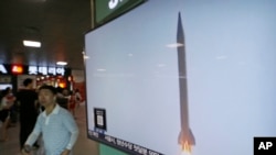 FILE - A man passes by a TV news program with file footage of a North Korean rocket launch at the Seoul Railway Station in Seoul, South Korea, Wednesday, Aug. 3, 2016.