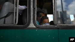 Un niño con tapabocas mira por la ventana de un autobús en Caracas, Venezuela. Sábado 6 de junio de 2020.