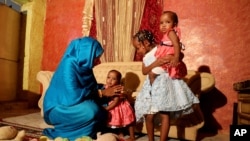 Youssria Awad, who refuses to carry out female genital mutilation on girls, with her daughters in Khartoum, Sudan, June 14, 2020, a practice that The World Health Organization says constitutes an ‘extreme form of discrimination’ against women.