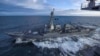 El destructor USS Kidd navega junto al portaaviones USS Theodore Roosevelt durante maniobras militares en el golfo de Alaska, el 16 de mayo de 2019. En estos momentos, ambas naves permanecen en puerto debido al nuevo coronavirus.