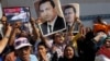 Supporters of former Egyptian President Hosni Mubarak hold his posters and a poster of Egyptian Army Chief Lt. Gen. Abdel-Fattah el-Sissi, left, in front of Tora prison in Cairo, Aug. 22, 2013.