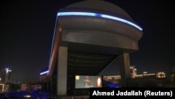 People sit in their cars watching a movie in a drive-in cinema at the Mall of the Emirates, following the outbreak of the coronavirus disease (COVID-19), in Dubai, United Arab Emirates, May 13, 2020. (REUTERS/Ahmed Jadallah)