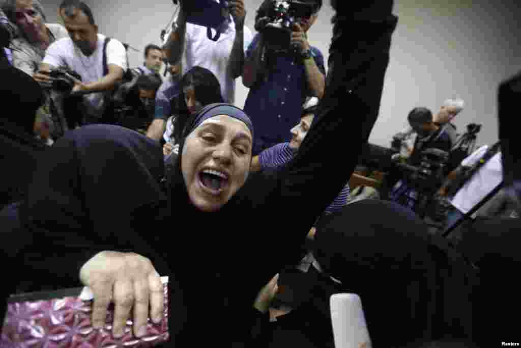 Family members of Abu Qatada hug as they celebrate after he was acquitted at the State Security Court in Amman, Sept. 24, 2014.