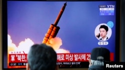 People watch a TV showing a file picture for a news report on North Korea firing two unidentified projectiles, in Seoul, South Korea, March 2, 2020.