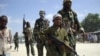 FILE - A young boy leads militant Islamist al-Shabab fighters as they conduct military exercises in northern Mogadishu's Suqaholaha neighborhood, Somalia, Jan. 1, 2010.